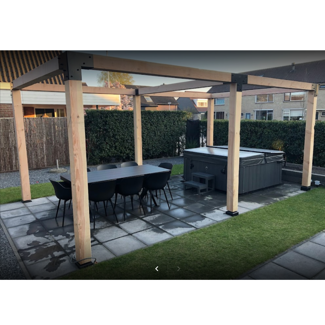 Houten pergola met metalen koppelstukken, geplaatst boven een eettafel en jacuzzi. Robuuste Douglas constructie ideaal als luxe buitenoverkapping in de tuin.